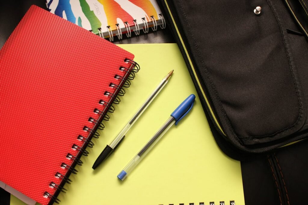 A close-up view of colorful notebooks and pens, perfect for educational themes.